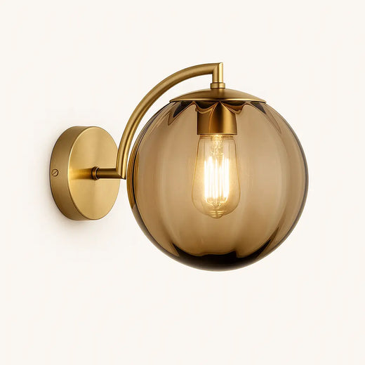 Luminaire mural rond en laiton, bras courbé, globe teinté, ampoule filament visible.