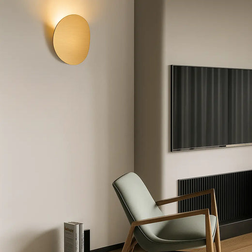 LUMINAIRE MAISON applique murale dorée ronde LED aluminium, design moderne éclairant le mur beige.