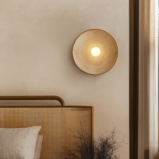 Applique murale ronde LED en résine ondulée, lumière chaude et apaisante diffusée élégamment.
