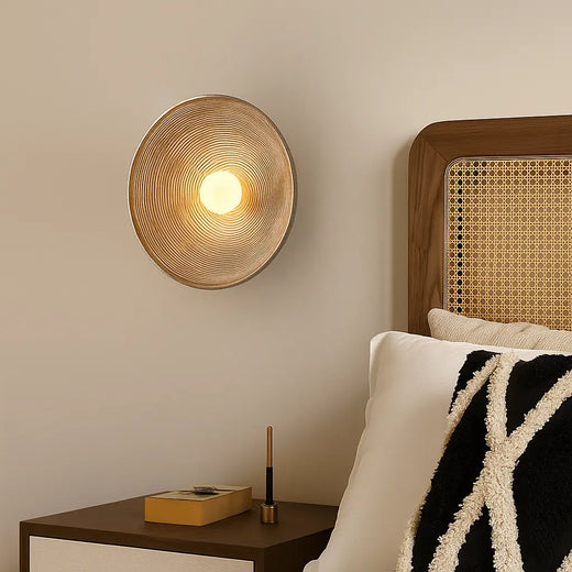 Luminaire mural LED rond en résine ondulée wabi-sabi diffusant une lumière chaude.