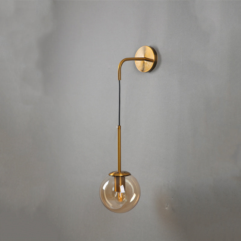 Luminaire mural Tyla doré ou noir, monture ronde, bras courbé, globe verre suspendu.