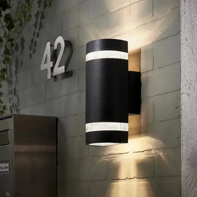 Applique LED cylindrique en acier brossé, lumière directe/indirecte pour terrasse contemporaine.