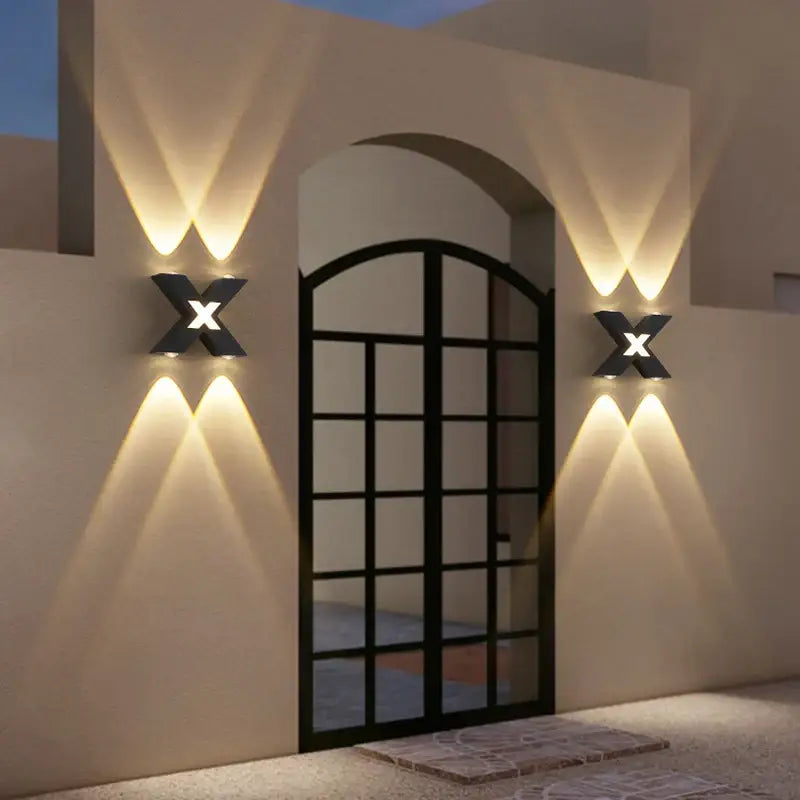 Deux appliques murales LED en X diffusent une lumière élégante vers le haut et le bas.