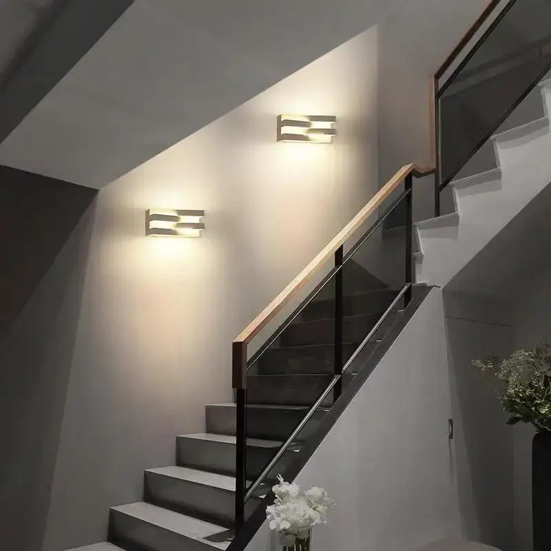 Deux appliques LED modernes en aluminium illuminent élégamment l'escalier.