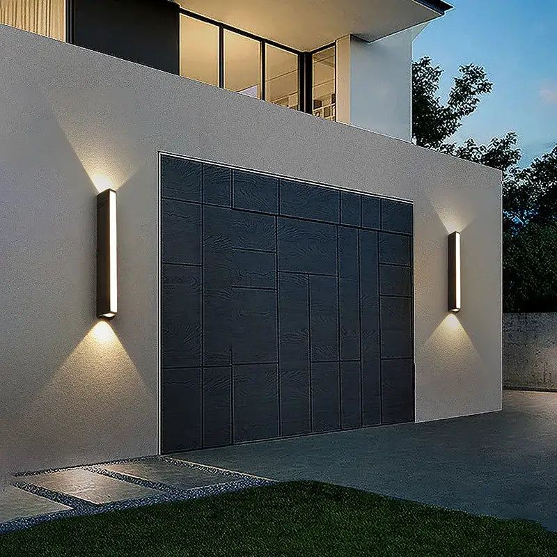 Deux applications LED rectangulaires projettent une lumière chaleureuse haut/bas sur façade sombre.