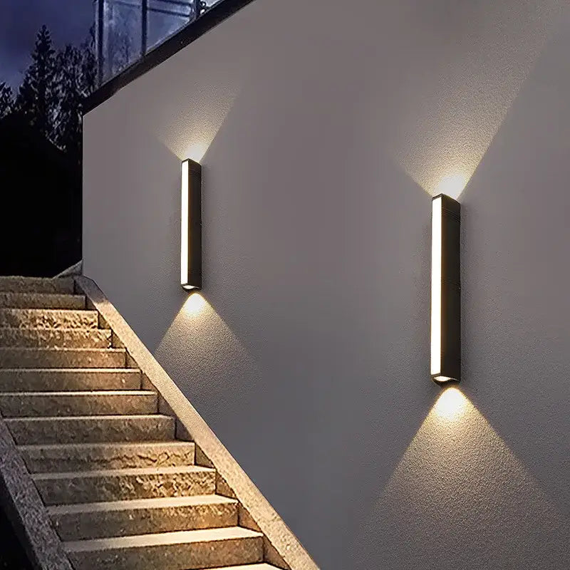 Deux appliques LED rectangulaires en aluminium diffusent une lumière douce vers le haut et le bas.