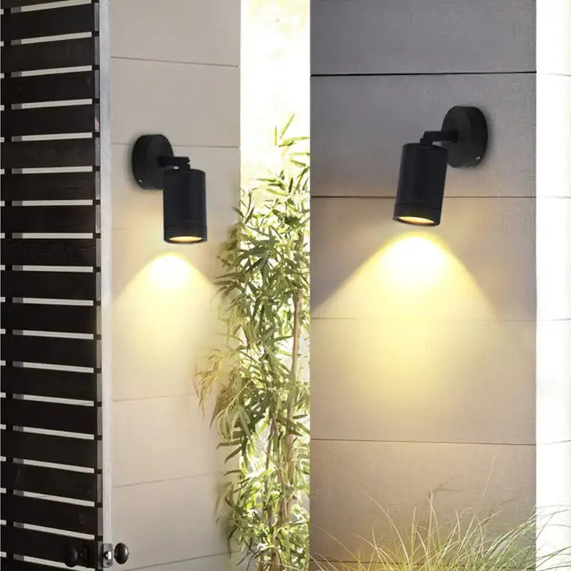 Applique murale LED inoxydable montée sur mur clair, diffusant une lumière chaude.