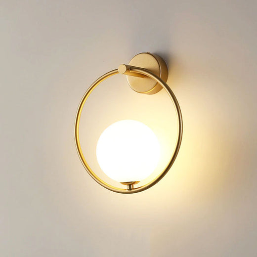 Applique LED ronde, dorée, forme lune, ajustable et moderne pour un éclairage raffiné.