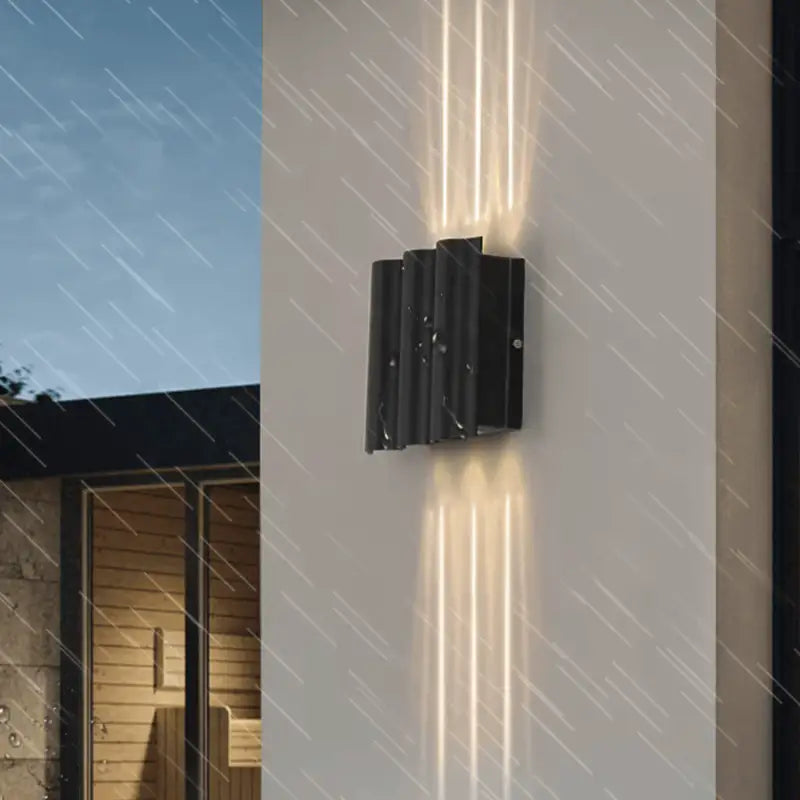 Luminaire mural LED en aluminium projetant des faisceaux verticaux lumineux sur un mur blanc.