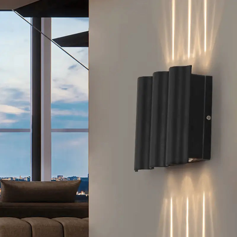 Applique murale LED aluminium ondulé, diffuse un éclairage doux vertical sur mur beige.