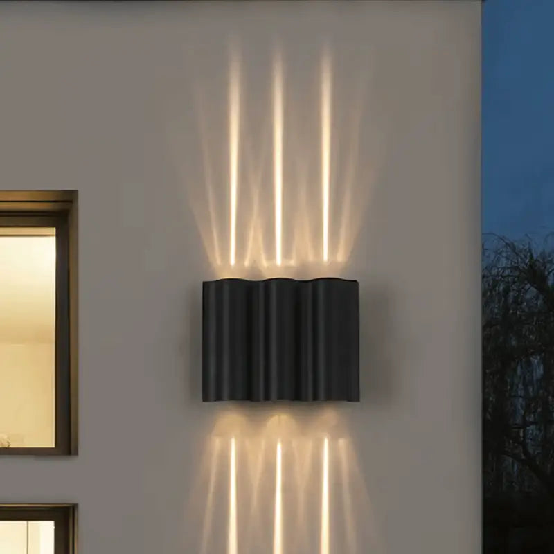 Applique murale LED aluminium ondulé diffusant une lumière douce aux motifs verticaux élégants.