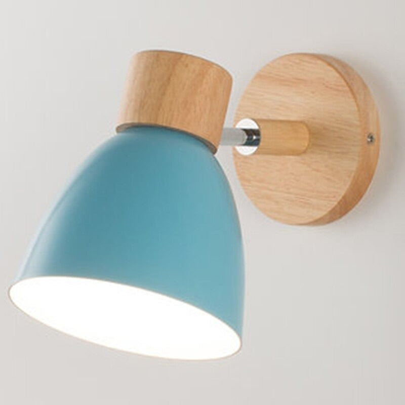 Luminaire scandinave bois métal, base ronde, abat-jour bleu, éclaire le mur blanc.