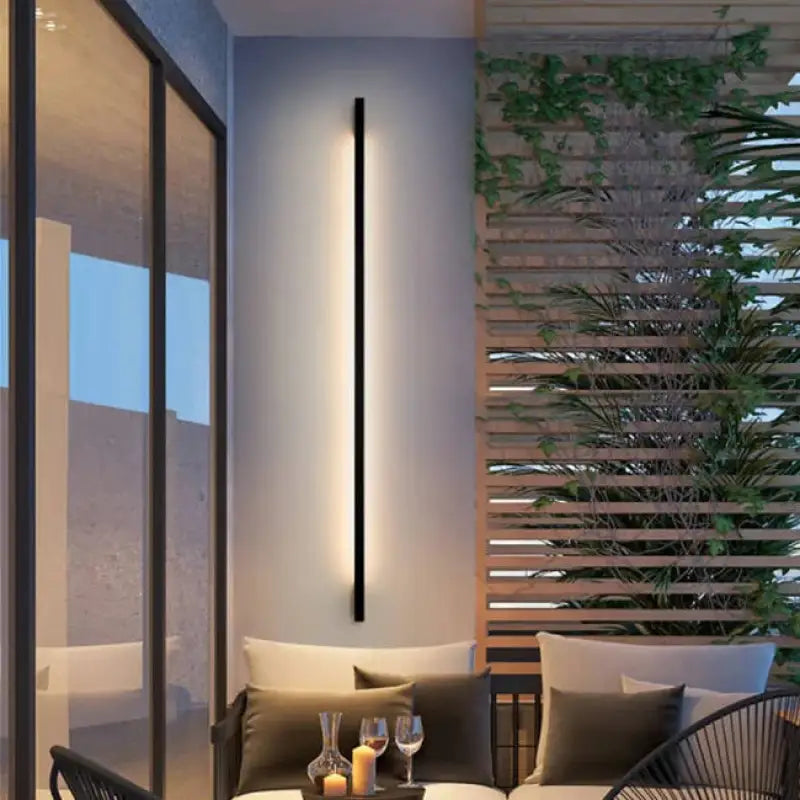 La LUMINAIRE MAISON Applique murale extérieur LED Élancée en Aluminium diffuse une lumière chaleureuse.