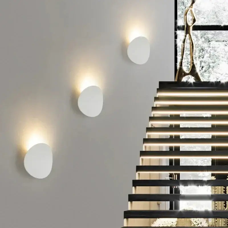 Trois appliques LED rondes LUMINAIRE MAISON en aluminium diffusent une lumière douce ascendante.