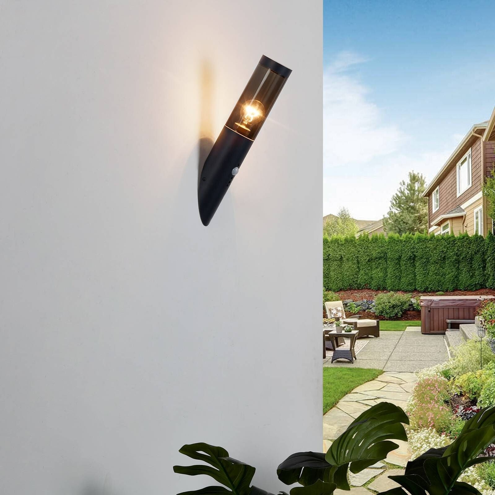 Un luminaire mural extérieur noir LUMINAIRE MAISON détecteur de mouvement fixé sur un mur blanc.