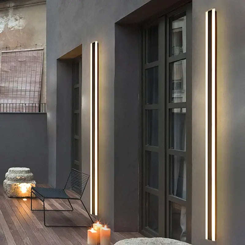 Grande applique murale LED extérieure noire ultra-moderne, parfaitement intégrée à la façade grise.